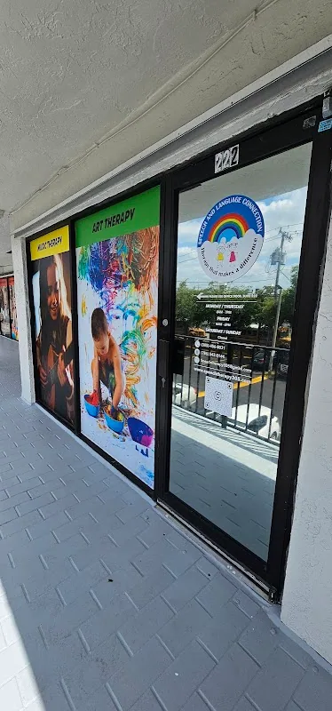 Storefront of the Speech and Language Connection clinic with Music Therapy and Art Therapy window posters and the clinic logo on the glass door